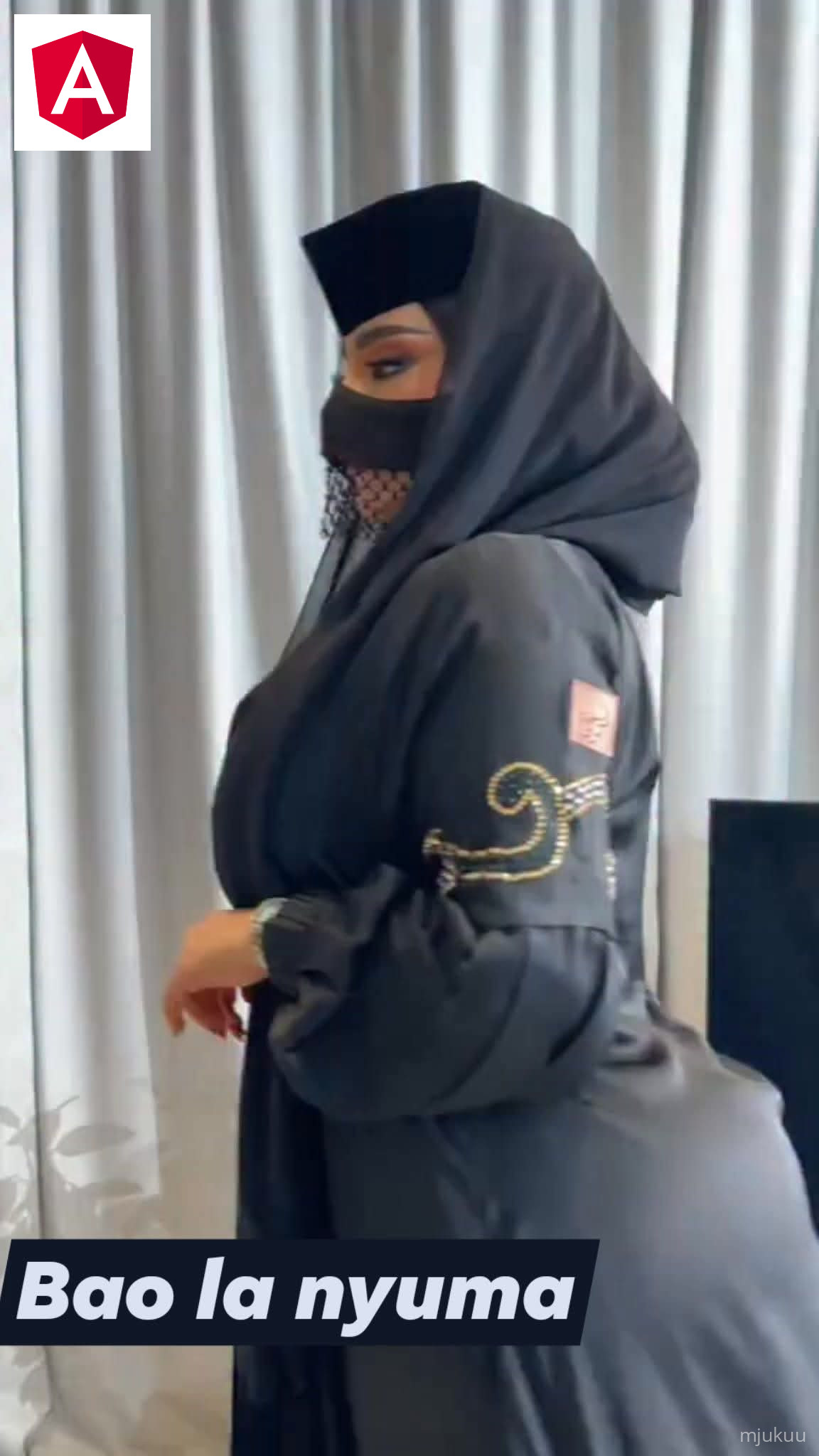 A person in a purple dress is cooking over an open fire inside a rustic kitchen with stone walls and a small window.